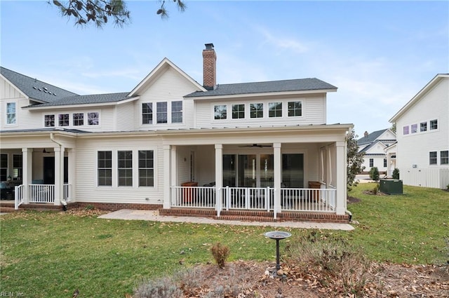 rear view of house featuring a patio area, a lawn, a chimney, and ceiling fan