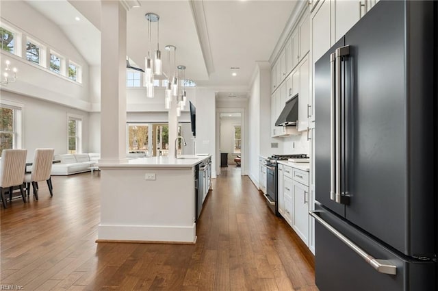 kitchen featuring under cabinet range hood, dark wood-style floors, light countertops, and appliances with stainless steel finishes