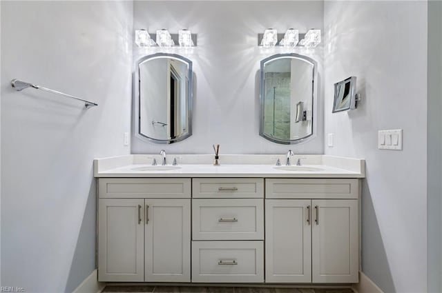 bathroom featuring double vanity, baseboards, and a sink