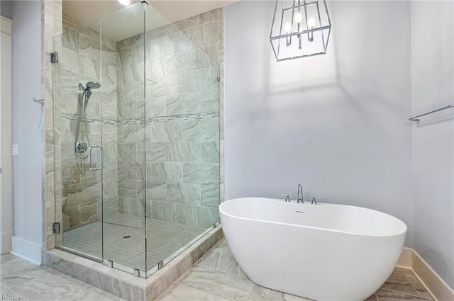 full bath with a freestanding tub, baseboards, a stall shower, and marble finish floor