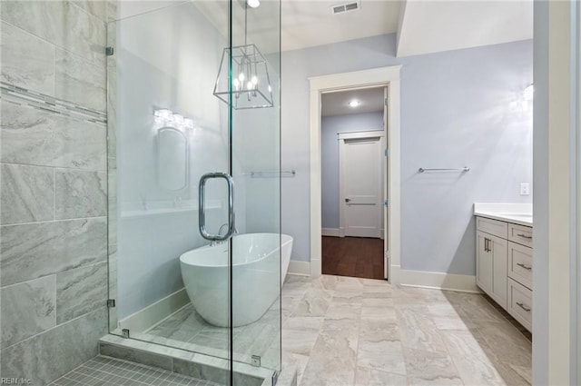 bathroom featuring visible vents, a shower stall, baseboards, a freestanding tub, and vanity