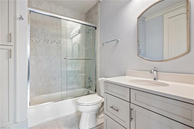 bathroom featuring tile patterned flooring, toilet, vanity, and shower / bath combination with glass door