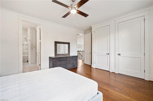 bedroom with a ceiling fan, crown molding, wood finished floors, and ensuite bathroom