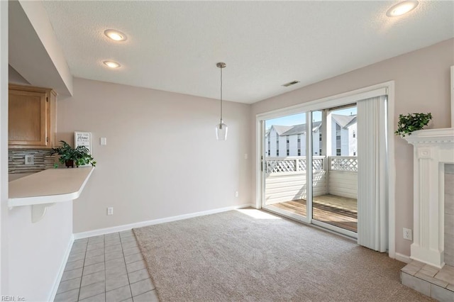 unfurnished dining area with baseboards, visible vents, recessed lighting, a textured ceiling, and light colored carpet