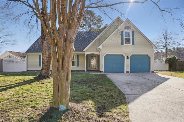 traditional-style home with a front yard, an attached garage, fence, and driveway