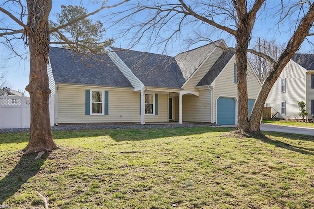 view of front of home featuring a garage, roof with shingles, a front yard, and fence