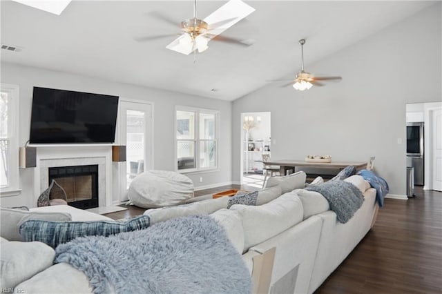 living area featuring visible vents, ceiling fan, lofted ceiling, a fireplace, and dark wood-style floors