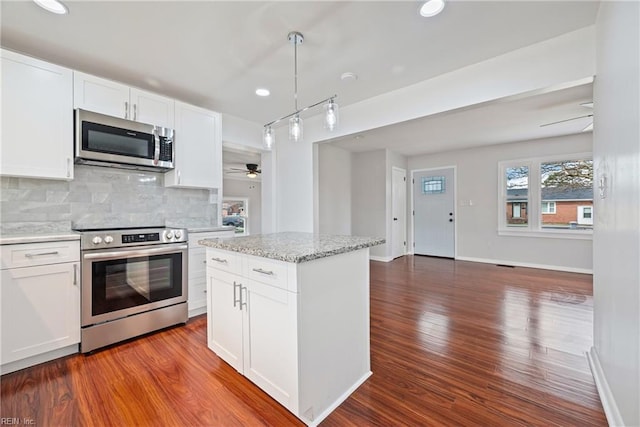 kitchen with ceiling fan, decorative backsplash, appliances with stainless steel finishes, dark wood-style floors, and white cabinetry