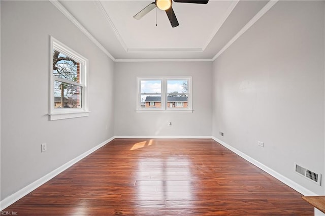 spare room featuring wood finished floors, visible vents, a wealth of natural light, and ceiling fan