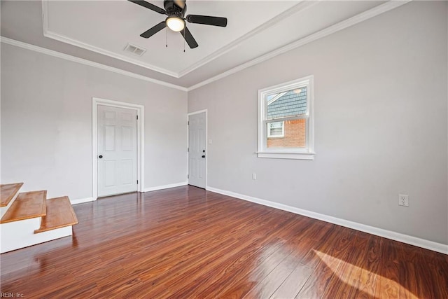 empty room featuring visible vents, crown molding, baseboards, ceiling fan, and wood finished floors