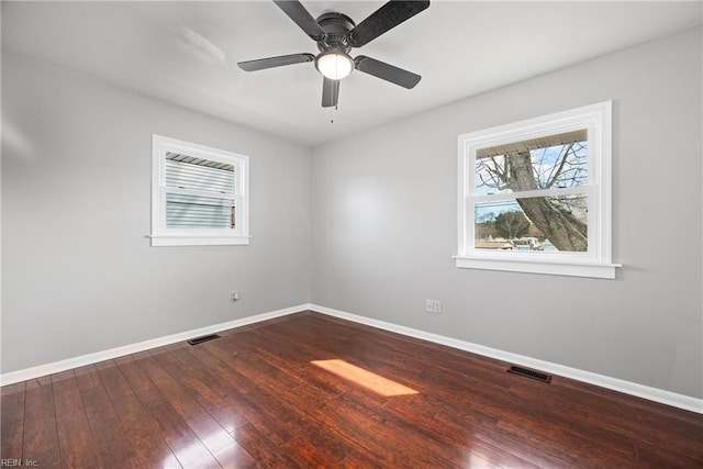 spare room featuring visible vents, a ceiling fan, baseboards, and wood-type flooring