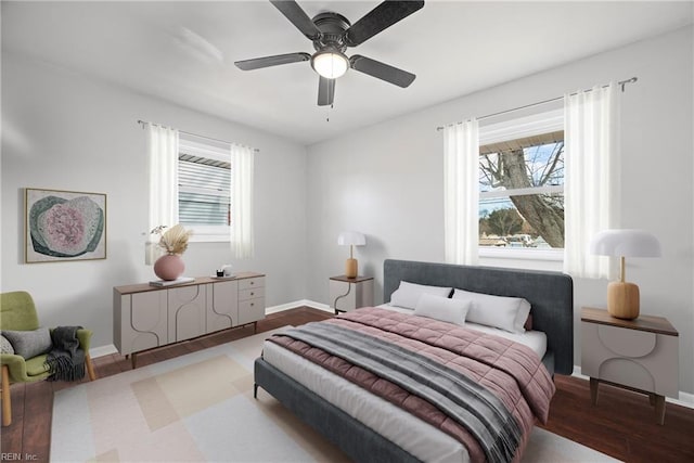 bedroom featuring ceiling fan, baseboards, and wood finished floors