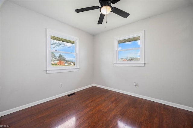 spare room with wood-type flooring, baseboards, and a wealth of natural light