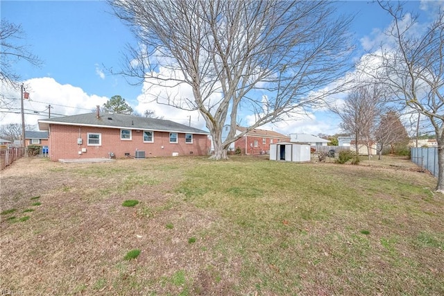 view of yard featuring a storage shed, central AC, a fenced backyard, and an outbuilding