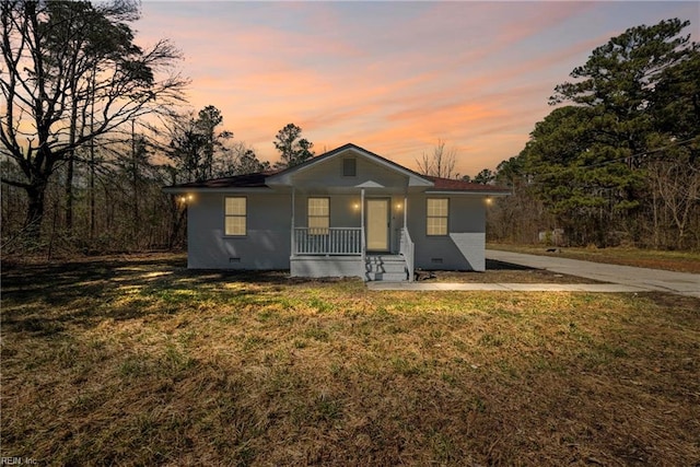 bungalow-style home featuring a porch, a yard, and crawl space