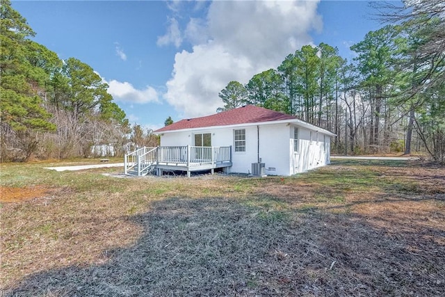 rear view of property featuring central AC and a wooden deck