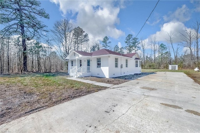 view of home's exterior with a yard, covered porch, and driveway