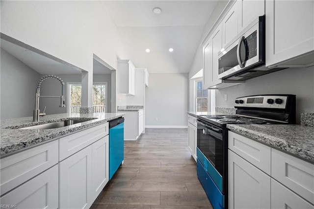 kitchen with stainless steel microwave, dishwashing machine, wood finished floors, electric range, and a sink