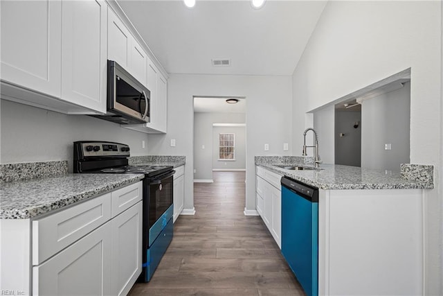 kitchen featuring stainless steel microwave, range with electric cooktop, dishwasher, wood finished floors, and a sink