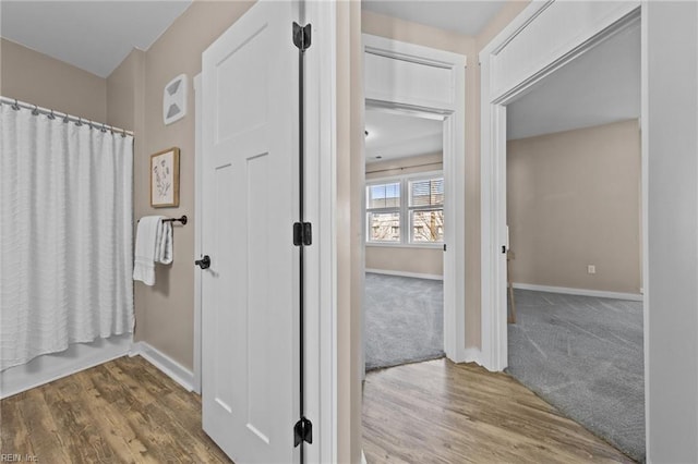 full bathroom featuring a shower with curtain, wood finished floors, and baseboards