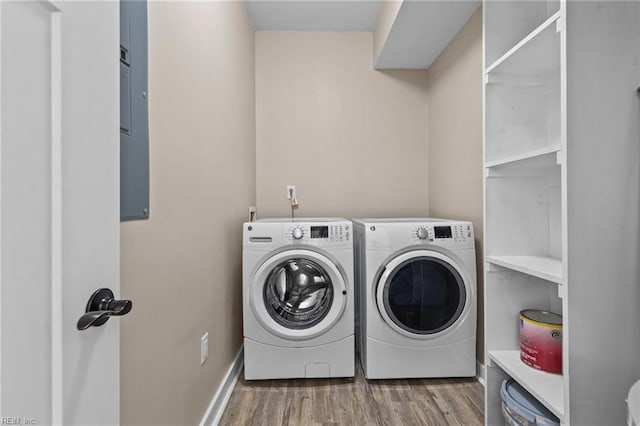 laundry area featuring washing machine and clothes dryer, laundry area, and wood finished floors