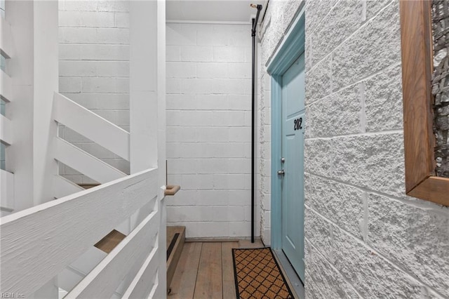 bathroom featuring hardwood / wood-style flooring and concrete block wall