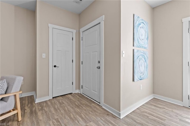 entrance foyer with baseboards and light wood-style floors