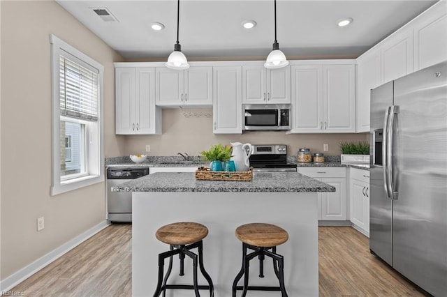 kitchen featuring a kitchen island, light wood-style flooring, white cabinetry, and stainless steel appliances