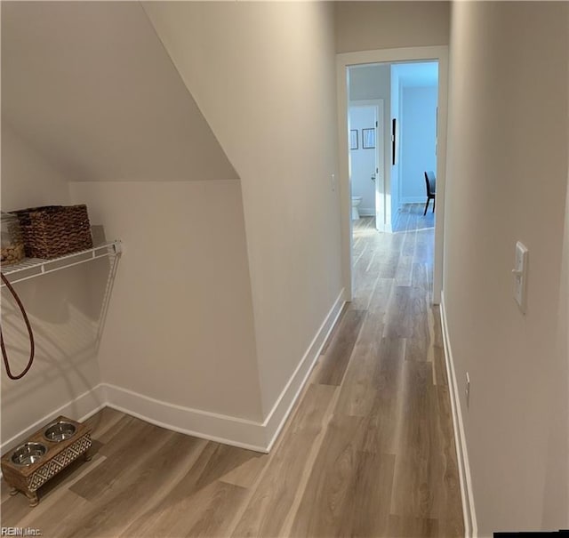 hall with baseboards and wood finished floors