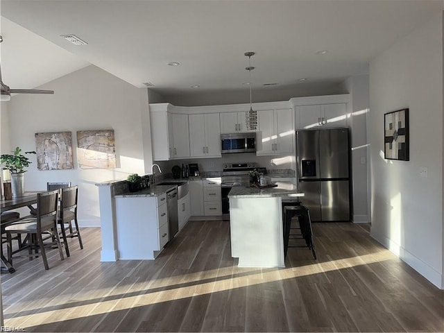 kitchen featuring light wood-type flooring, visible vents, a breakfast bar, a center island, and appliances with stainless steel finishes