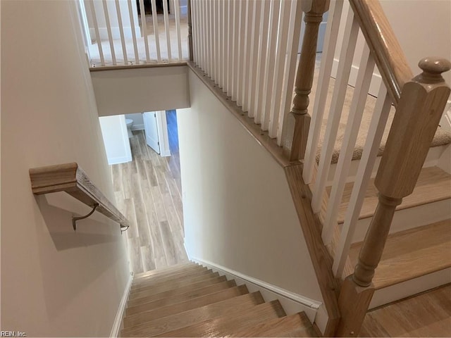 staircase with wood finished floors and baseboards