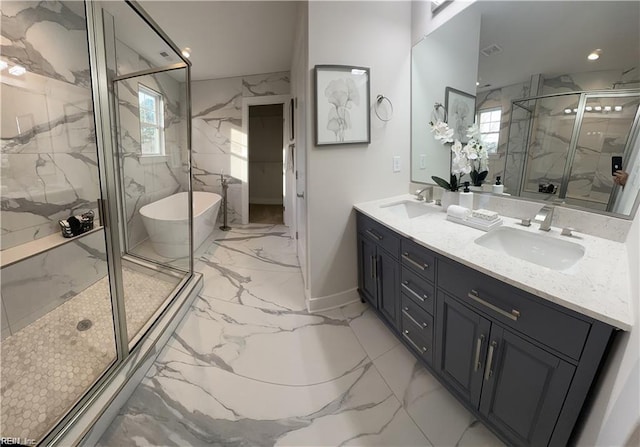 full bathroom featuring a marble finish shower, marble finish floor, double vanity, and a sink