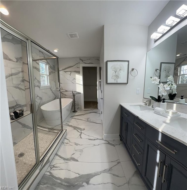 bathroom featuring vanity, a soaking tub, marble finish floor, and a marble finish shower