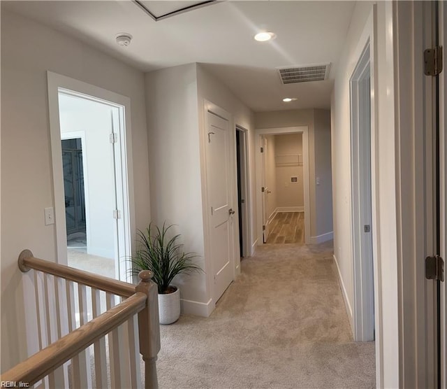 hallway with visible vents, light carpet, an upstairs landing, recessed lighting, and baseboards