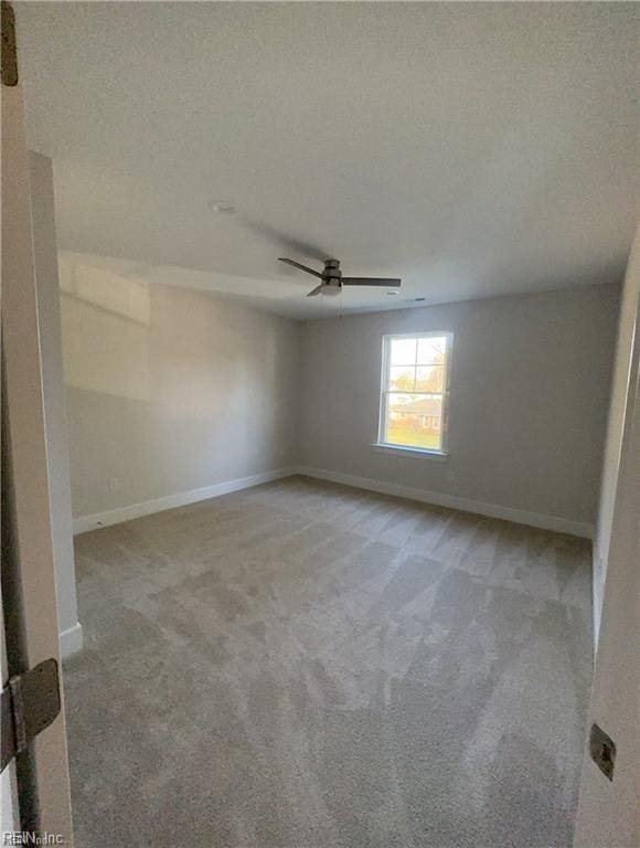 spare room featuring baseboards, carpet, a ceiling fan, and a textured ceiling