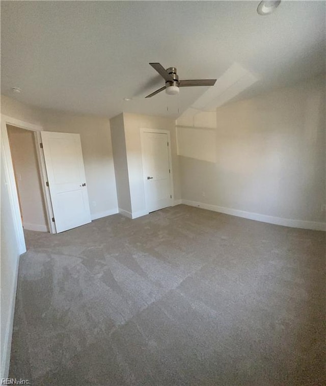 carpeted spare room featuring ceiling fan, a textured ceiling, and baseboards