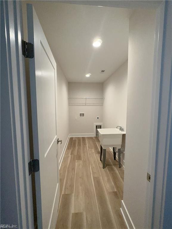 bathroom featuring a sink, visible vents, baseboards, and wood finished floors