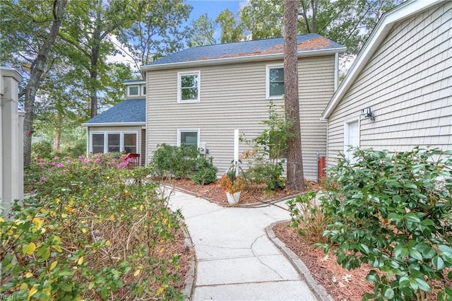 rear view of property featuring roof with shingles