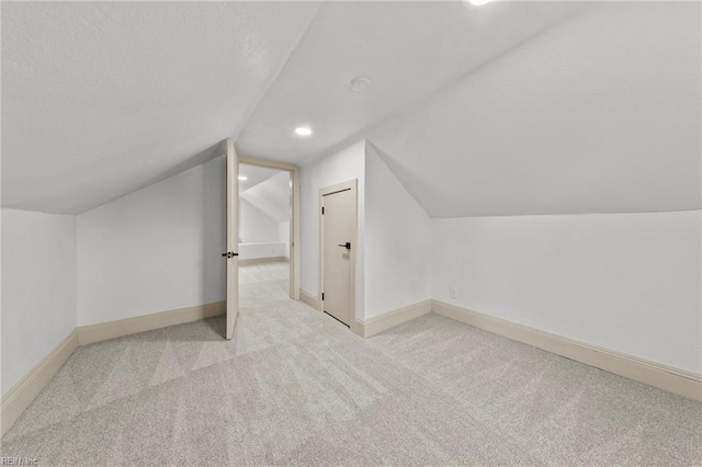 bonus room with baseboards, a textured ceiling, carpet floors, and vaulted ceiling