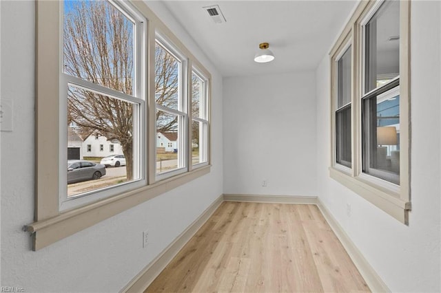 interior space featuring visible vents, baseboards, and wood finished floors