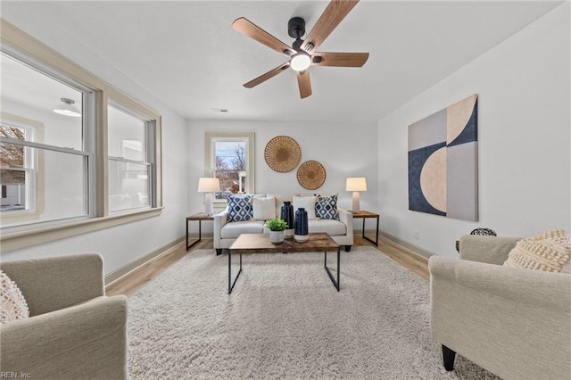 living room featuring a ceiling fan, wood finished floors, and baseboards