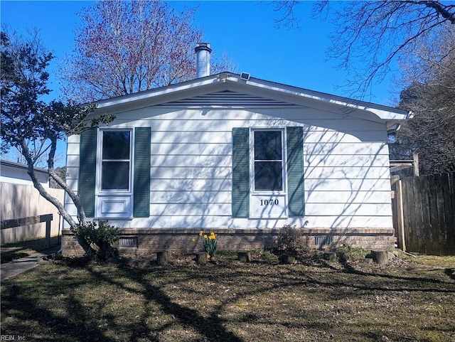 view of side of property featuring fence and crawl space