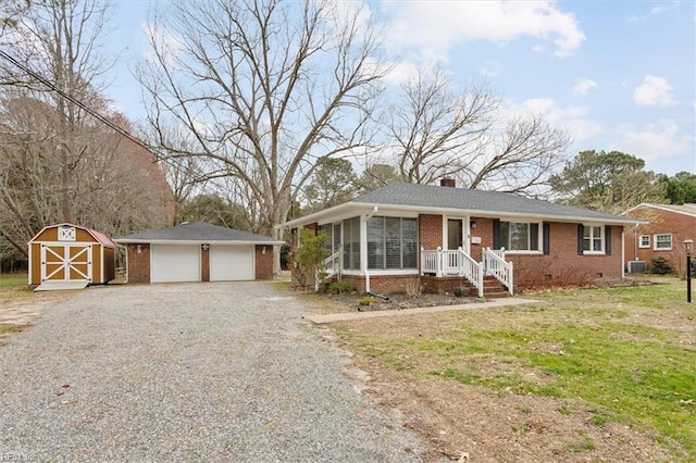 view of front of home featuring a sunroom, a chimney, an outdoor structure, crawl space, and brick siding