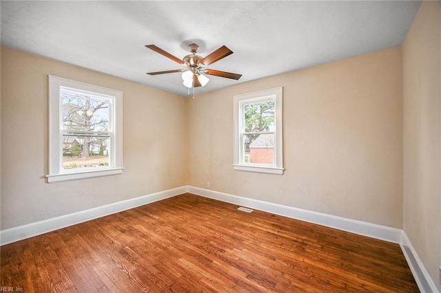 unfurnished room featuring visible vents, a ceiling fan, baseboards, and wood finished floors