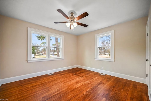 empty room with a ceiling fan, wood finished floors, baseboards, and visible vents