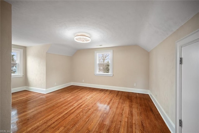 bonus room featuring vaulted ceiling, baseboards, and wood finished floors