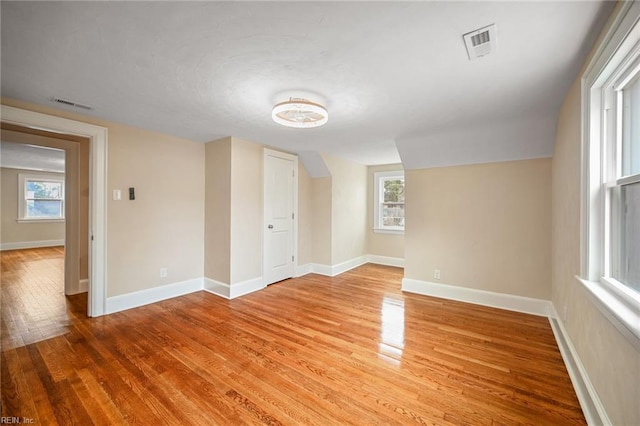 unfurnished room with visible vents, light wood-style flooring, and baseboards