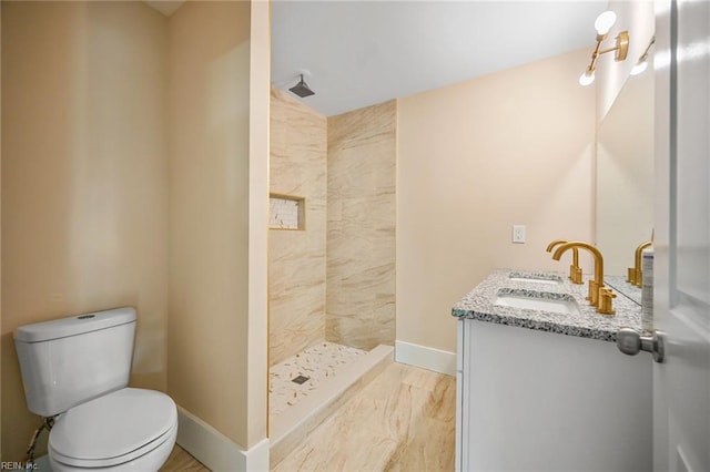 full bathroom featuring baseboards, toilet, a stall shower, and vanity