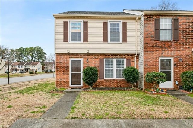 view of front of house featuring brick siding and a front lawn