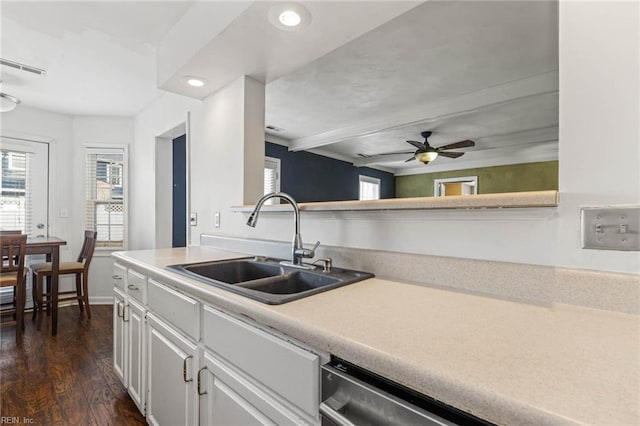 kitchen with white cabinetry, light countertops, a wealth of natural light, and a sink